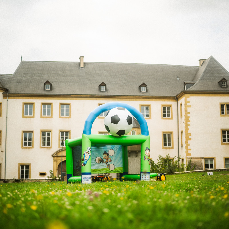 Structure gonflable Goal avec ballon de foot et cage devant un château luxembourgeois.